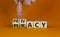 Privacy vs piracy symbol. Businessman hand turns cubes and changes the word `piracy` to `privacy`. Beautiful orange background