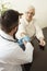 A private doctor`s office. Doctor examining an old woman`s hand.