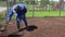 Private house owner sowing lawn grass seeds in yard. Handheld motion shot