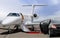 Private jet and black car waiting on landing strip in airport