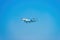Private jet on blue sky. Business jet. Luxury twin engine plane fly over urban areas preparing landing