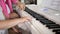 Private music teacher giving piano lessons to little girl. Hands close up.