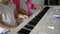 Private music teacher giving piano lessons to little girl. Hands close up.