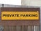 Private parking sign attached to a wooden fence