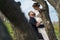 Private photo peeping from behind the bride and groom from the trees. Amorous couple on a natural background. In artistic creative