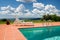 Private pool with beautiful view of landscape in Tuscany with blue sky