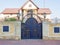 Private villa with stone fence and iron decorative gates with a wrought gilded pattern