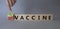 Pro-vaccine vs Anti-vaccine symbol. Doctor hand points at cubes with words Anti-vaccine vs Pro-vaccine. Beautiful grey background