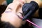 Procedure for long-term eyebrow styling is close-up, the master applies the composition for lamination of eyebrows with a