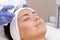 The procedure of steaming the skin of the face of a young woman before cleaning the skin