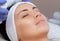 The procedure of steaming the skin of the face of a young woman before cleaning the skin