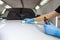 The process of applying a nano-ceramic coating Ceramic Pro 9h and Light on the car`s hood by a male worker with a sponge and