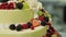 The process of cake making. Pastry chef decorates a cake with berries