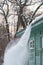 Process of cleaning roof from snow with shovel. Danger of snow or icicles falling from rooftop