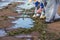 Process of cleaning up the shore beach line from litter garbage rubbish trash, group of eco volunteers remove oil products leak