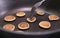 Process of cooking baked tiny pancake cereal - trendy quarantine food. Use fork to flip mini pancakes to other side on hot pan.