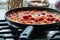 Process of cooking tomato sauce for pasta in a by the ingredients: onion, greens, radish, tomato, paprika and red pepper