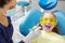 Process of drying the dental seal after treatment of the patient`s tooth in pediatric dentistry. Little girl in dentist office