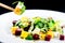 Process of eating with Chinese chopsticks delicious and appetizing salad with beetroot and fruit mango. Dish in a white plate