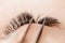 Process Eyelash extension procedure top view. Master tweezers fake 5d lashes beautiful woman eyes