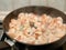 The process of frying shrimp in a pan