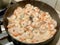 The process of frying shrimp in a pan