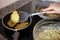 Process frying zucchini pancakes in frying pan in kitchen