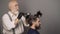 Process of a guy having hair dyed at hairdresser salon. Hipster bearded men dye his hair color on a gray background