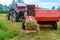 The process of harvesting hay for cattle, a tractor making bales in the field, old machinery