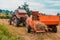 The process of harvesting hay for cattle, a tractor making bales in the field, old machinery