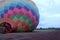 Process of inflation and preparation of hot air balloon at sunrise for flight in cloudy sky