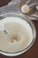 Process of kneading the dough with a mixer in a large glass bowl.