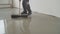 The process of laying the self-leveling floor. Compaction of dry cement-sand mixture. Liquid floor. The master levels the floor