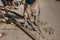 The process of laying the sidewalk curb. Workers place a deflected piece of concrete curb into a prepared recess or trench