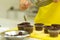 The process of making chocolate cupcakes with sweet cream. Creation of cakes by professional pastry chefs