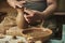 Process of making clay pot on potter`s wheel in workshop. Potter at work