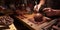 A process of making craft chocolate. Human hands at work, close-up, low key, selected focus.