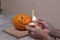 The process of making a Halloween pumpkin. light a match and candle. horror theme and Hallowe`en