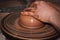 The process of making pottery. Craftsman`s hands. Work on a potter`s wheel