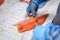 The process of manual filleting of red fish. The worker cuts the fish into pieces with a knife.