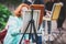 Process of plein air painting, group class of adult talented students in the park with paints easels, and canvases during lesson