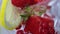 The process of pouring water into a summer cocktail with strawberries, berries, lemon and ice