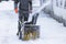 Process of removing snow with portable blower machine, worker dressed in overall workwear with gas snow blower removal on the