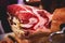 A process of slicing Hamon Jamon, traditional spanish ham on a wooden stand, slices of Parma Ham, as a part of catering on