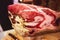 A process of slicing Hamon Jamon, traditional spanish ham on a wooden stand, slices of Parma Ham, as a part of catering on