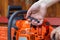 The process of starting a chainsaw. A male worker pulls the starting cable of a chainsaw with his hand. Close-up