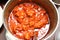 Process of stewing of pork goulash in a cast-iron pot.