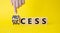 Process and Success symbol. Businessman Hand points at turned cube with words success and process. Beautiful yellow background.