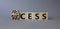 Process and Success symbol. Turned cube with words success and process. Beautiful grey background. Businessman hand. Business and