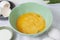 The process whisking egg yolks, making tasty egg omelet with green spinach for breakfast on white background. Idea